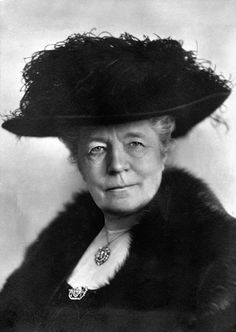 an old black and white photo of a woman wearing a large hat with fur on it