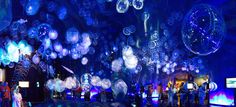 a room filled with lots of blue lights and balloons hanging from the ceiling above it