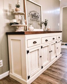 a kitchen with white cabinets and wood floors