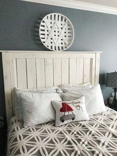 a white bed topped with pillows next to a night stand