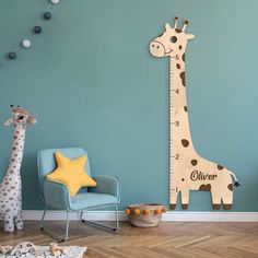 a wooden giraffe standing next to a blue chair in a child's room