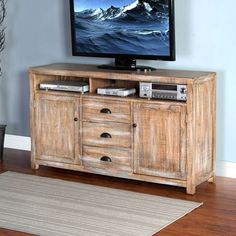 a flat screen tv sitting on top of a wooden cabinet