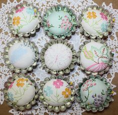 six decorated cupcakes sitting on top of a doily