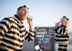 two people dressed in jail clothes are drinking from cans and one is holding a sign that says trouble maker on it