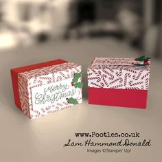 two boxes with christmas designs on them sitting side by side in front of each other