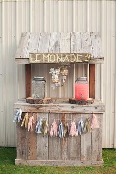 an old fashioned lemonade kiosk is decorated with ribbons and mason jar decorations