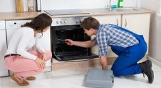 a man and woman looking into an oven