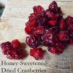 some cranberries on a cutting board with the words honey - sweetened dried cranberries