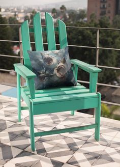 a green chair with a shark pillow on it's back sitting on a tiled patio