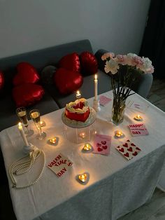 a valentine's day table setting with candles, flowers and cards on the table