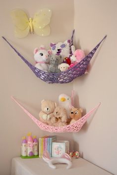 there are stuffed animals in a hammock hanging on the wall above a dresser