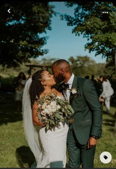 a bride and groom kissing in the grass