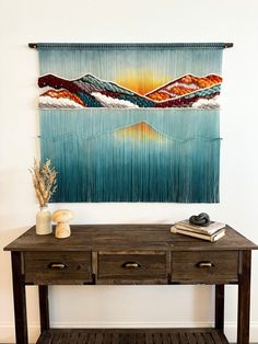 a painting hanging on the wall above a wooden table