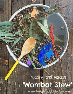 a bowl filled with plants and feathers on top of a wooden table