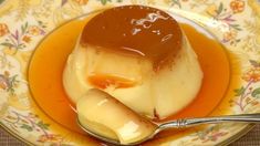 a plate with some kind of dessert on it and a spoon in the bowl next to it