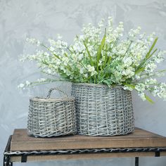 two wicker baskets with white flowers in them