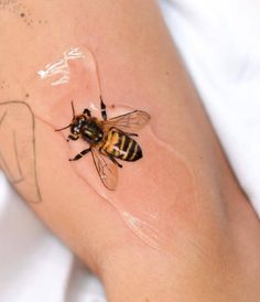 a close up of a person's arm with a bee on it