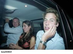 three people sitting in the back of a car with one person holding his hand up