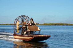 a man riding on top of a wooden boat in the water next to a ferris wheel