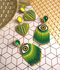 three pieces of beaded jewelry sitting on top of a tiled floor next to a basket