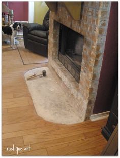 a living room with a fire place and dog standing in front of the fireplace looking at it