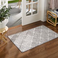 a white and black rug sitting on top of a wooden floor next to a door