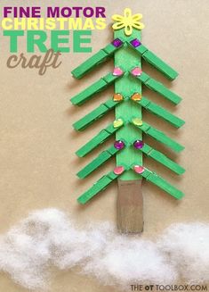 a green christmas tree made out of paper on top of a piece of wood with the words fine motor christmas tree craft