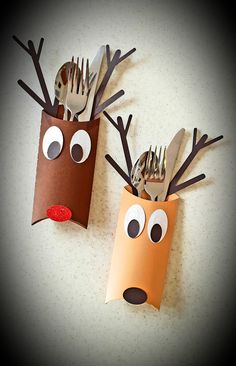 two reindeer paper cups with forks and spoons sticking out of them