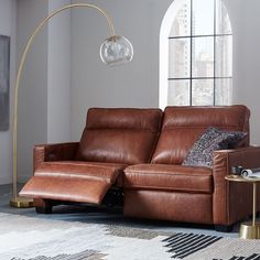 a living room with a couch, chair and lamp