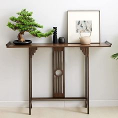 a wooden table with two vases and a small pine tree on it's shelf