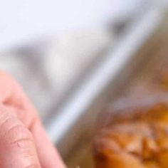 a close up of a person's hand with food in the background