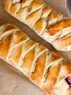 two pastry rolls sitting on top of a piece of wax paper next to each other