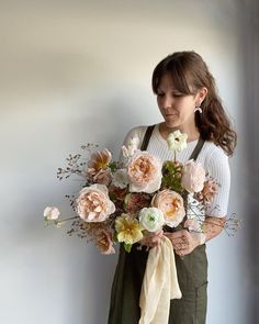 a woman holding a bouquet of flowers in her hands