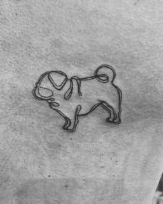 a black and white photo of a pug tattoo on the back of a man's chest