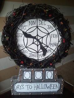 a clock that is sitting on top of a stand with some lights around it and the words days to halloween written on it