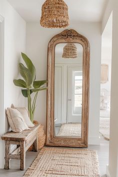 a large mirror sitting on top of a wooden floor next to a bench and potted plant