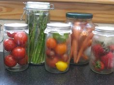 several jars filled with different types of vegetables