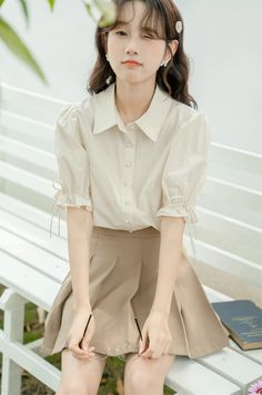 Basic but cute button up shirt with a classic collar, rounded buttons and short puff sleeves with ribbon-tied frilly cuffs. S: 14" across shoulders, 40" chest, 23.5" lengthM: 14.5" across shoulders, 41.5" chest, 23.5" lengthL: 15" across shoulders, 43" chest, 24" length Casual Blouse With Puff Tie Sleeves, Spring Office Lady Blouse With Puff Sleeves, Spring Office Lady Puff Sleeve Blouse, Spring Puff Sleeve Blouse For Office, Summer Puff Sleeve Shirt With Cuffed Sleeves, Beige Short Sleeve Blouse With Button Closure, Beige Blouse With Button Closure And Short Sleeves, Summer Puff Sleeve Blouse With Button Cuffs, Summer Blouse With Puff Sleeves And Button Cuffs