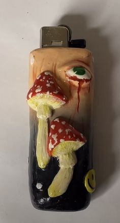 a close up of a cell phone with an evil face on the front and two mushrooms on the back