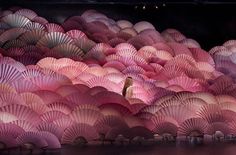 a large group of umbrellas that are in the dark room with lights on them