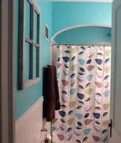 a bathroom with blue walls and a shower curtain