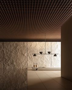 an empty room with some lights on the ceiling and two lamps hanging from the ceiling