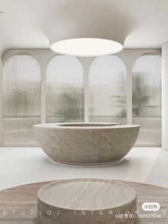 a large stone bathtub sitting in the middle of a room next to two round windows