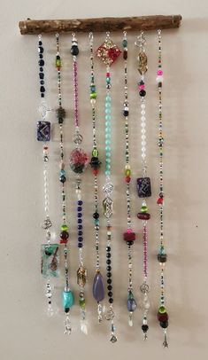 a wall hanging with beads and charms on it