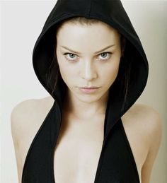 a woman wearing a black hoodie looking at the camera