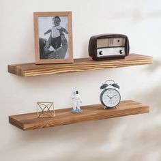 two wooden shelves with small figurines on them and an alarm clock next to it