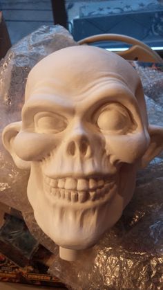 a white skull statue sitting on top of plastic wrap