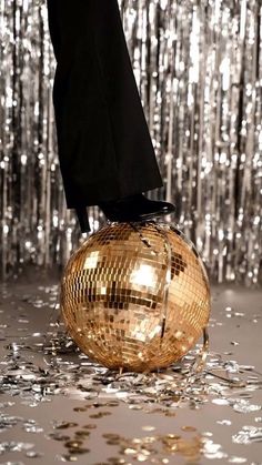 a person standing on top of a disco ball in the middle of confetti