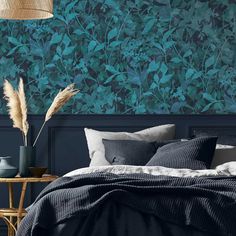 a bedroom with blue wallpaper and black bedding