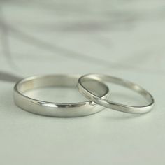 two wedding rings sitting on top of each other